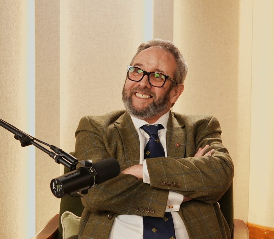 Al Kingsley in relaxed conversation in a studio, arms crossed