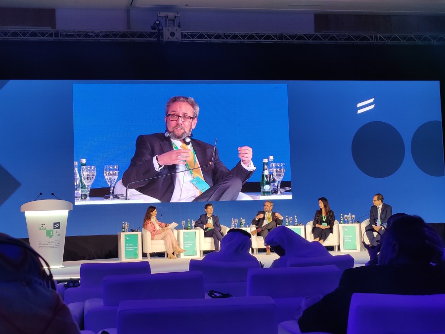 Al Kingsley chairing a panel on a conference main stage
