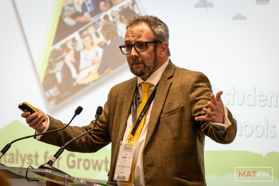 Al Kingsley speaking beside a slide on growth in schools