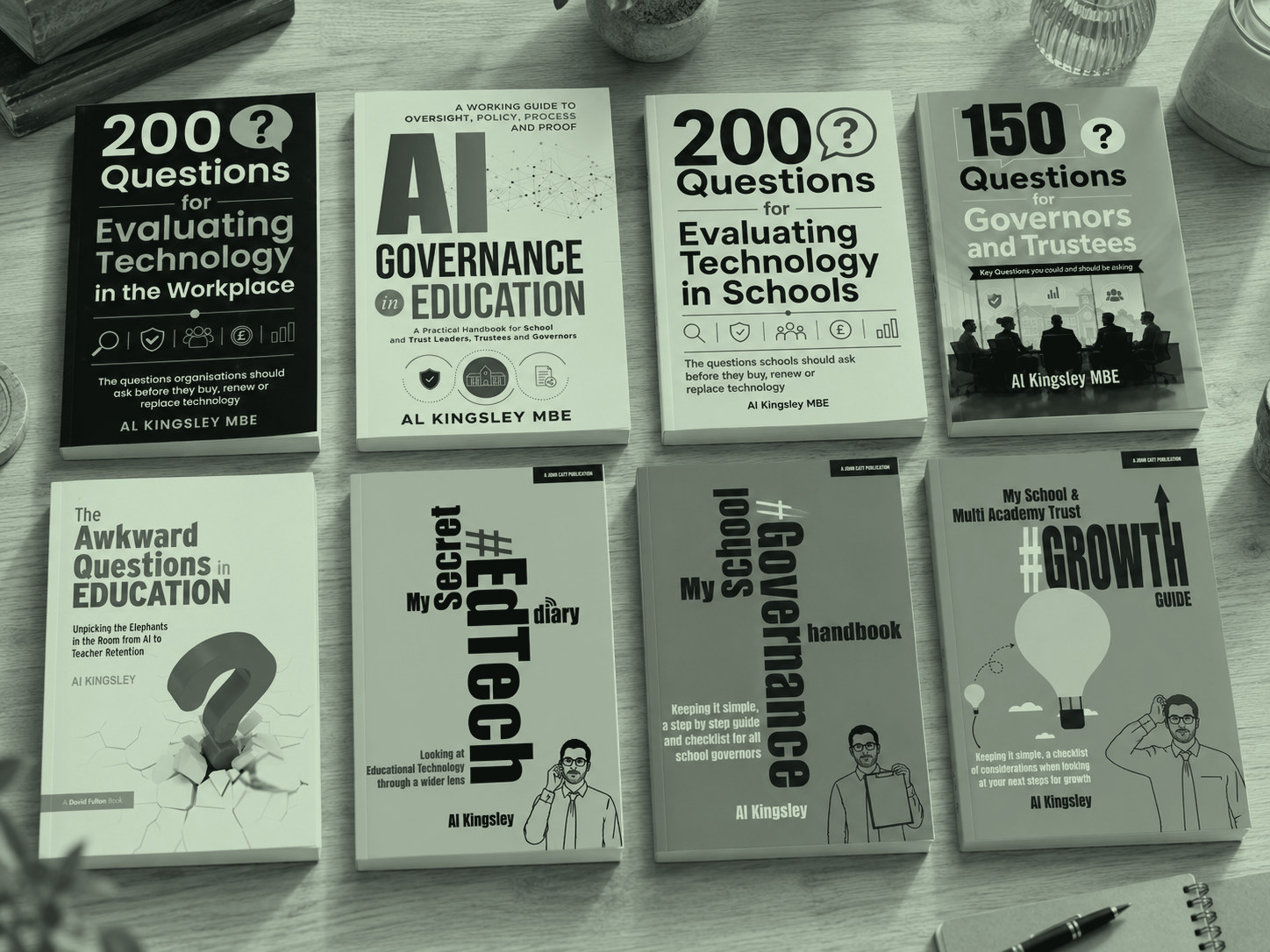 Eight of Al Kingsley’s books laid out together, from The Awkward Questions in Education to the governance and growth guides