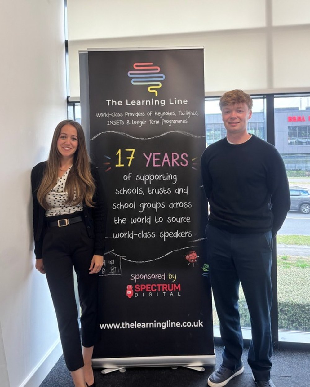 Katie Cavill and Sam Frankish of The Learning Line beside their banner